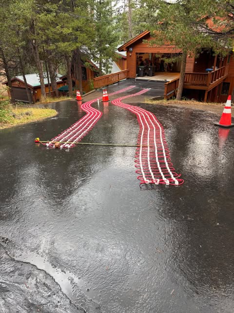 Heated driveway snow-melt mats laid like red tire tracks on asphalt